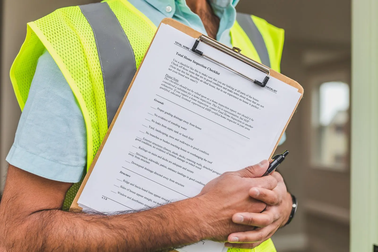 Close-up of an inspector holding a home inspection checklist on a clipboard