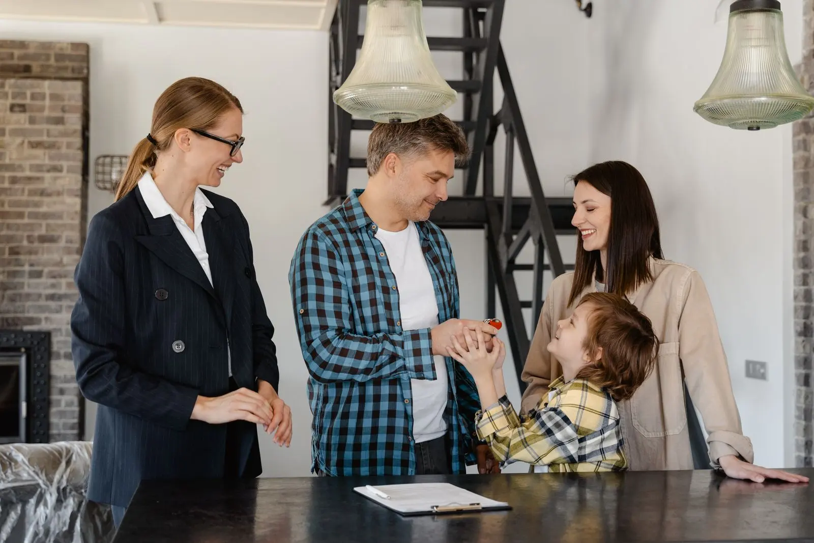 A family receiving the keys to their new home from a real estate agent