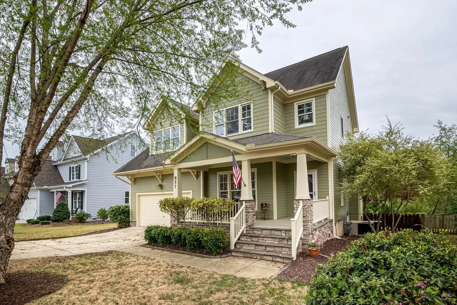 Two-story home with a covered front porch and an American flag